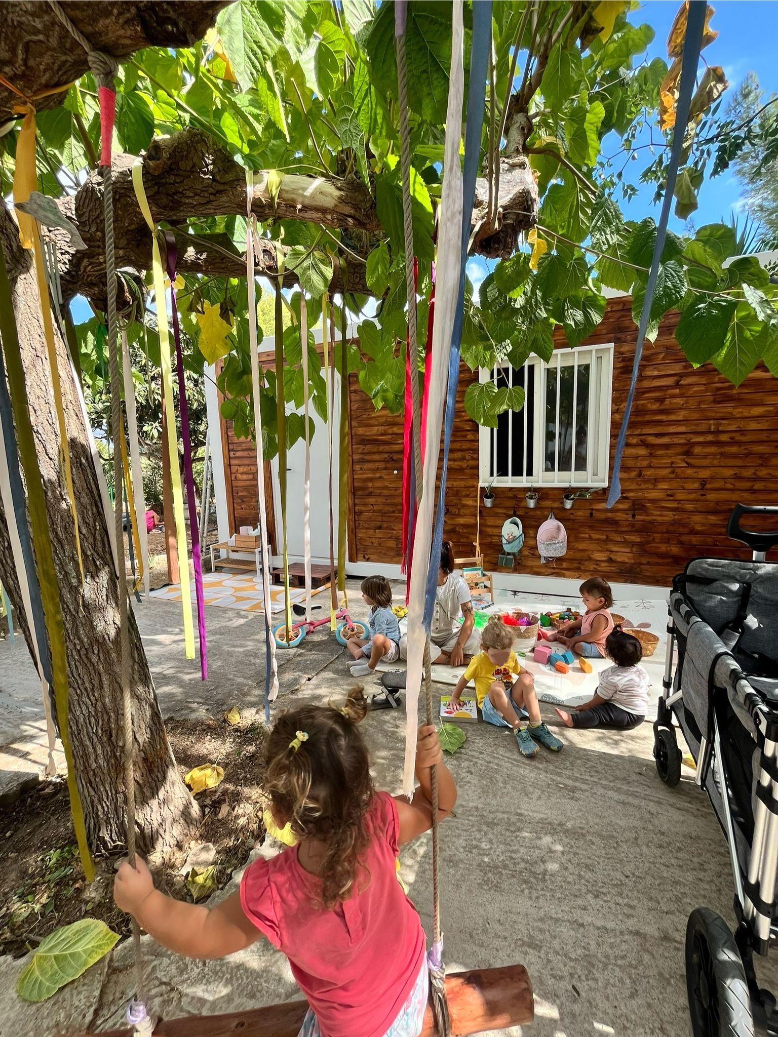 Infants jugant a l'espai exterior amb cintes de colors